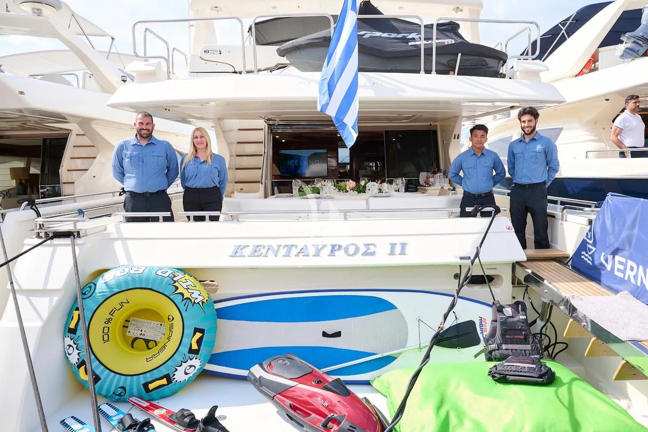 a group of people standing around a model airplane aboard KENTAVROS II Yacht for Charter