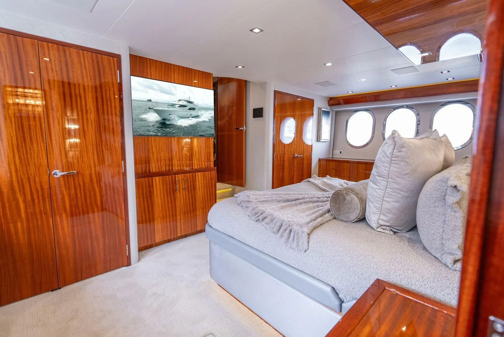 a bedroom with a bed and a wood door aboard RITZ SEA Yacht for Sale