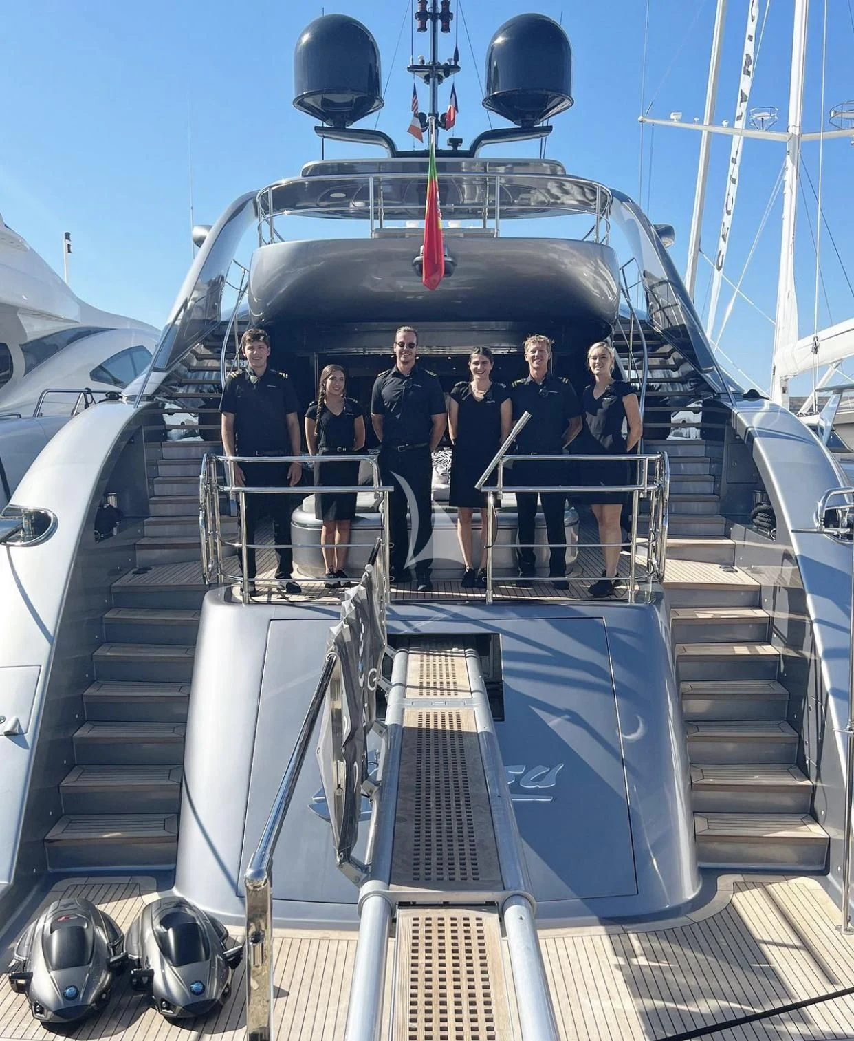 a group of people standing on a staircase in front of a helicopter aboard MATSU Yacht for Sale