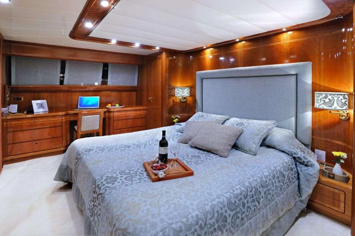 a bed with a bottle of wine aboard BLU SKY Yacht for Sale
