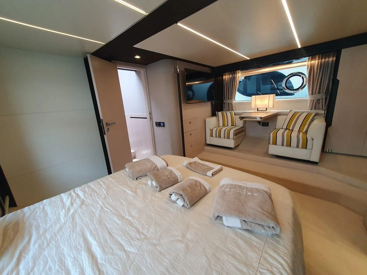 a bedroom with a bed and a table aboard PAVIMAR II Yacht for Sale