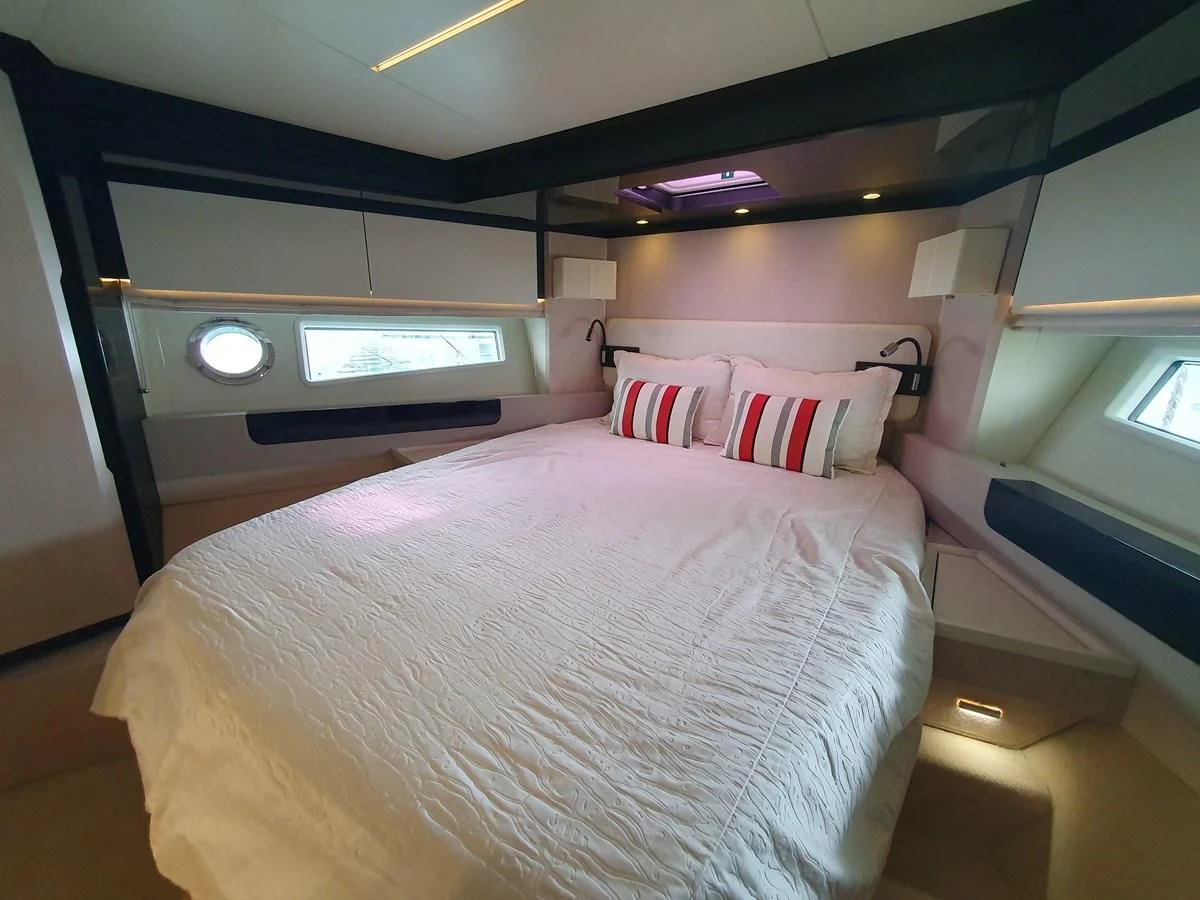 a bed with a white comforter aboard PAVIMAR II Yacht for Sale