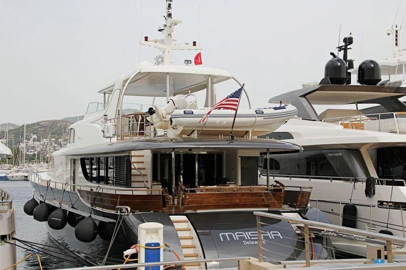 a boat with a flag on the deck aboard MAISHA Yacht for Sale