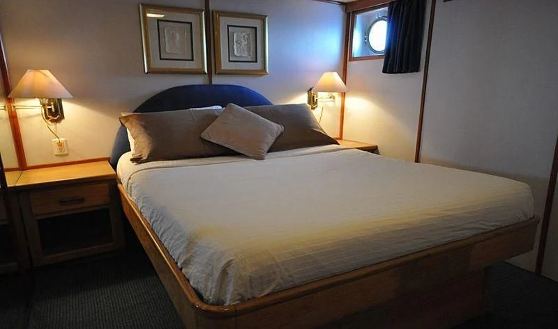 a bed with a white comforter aboard BELUGA Yacht for Sale