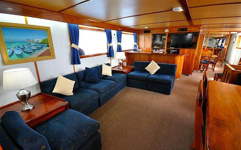 a living room with a blue couch aboard BELUGA Yacht for Sale