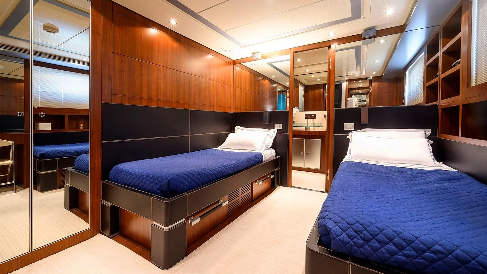 a room with a bed and a desk aboard BEYOND Yacht for Charter