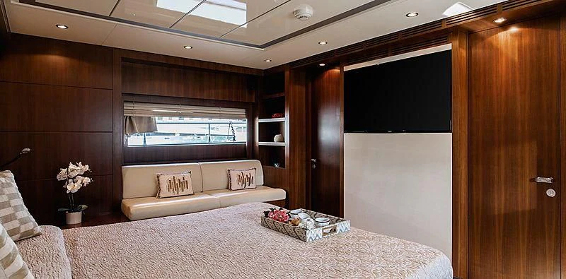 a room with a bed and a tv aboard BEYOND Yacht for Charter