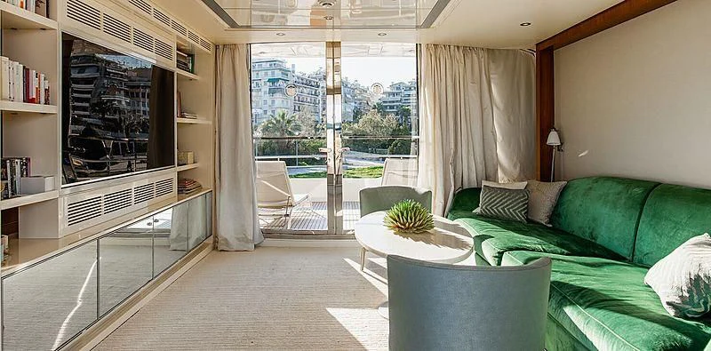 a living room with a couch and a bookcase aboard BEYOND Yacht for Charter