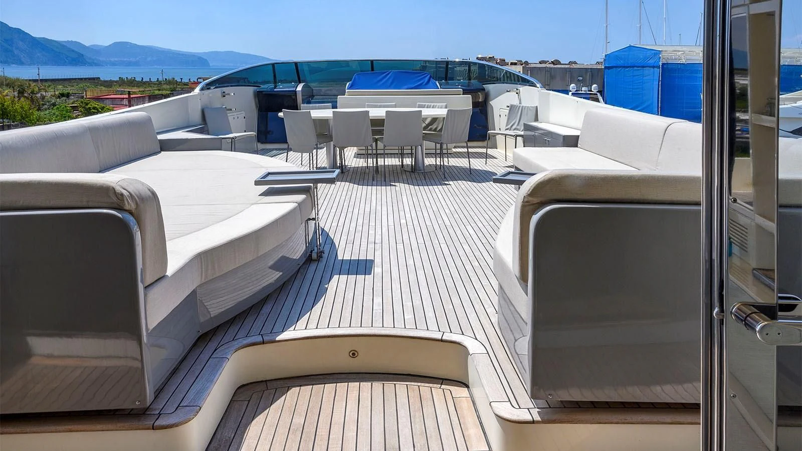 a balcony with a view of the ocean and the mountains aboard BEYOND Yacht for Charter