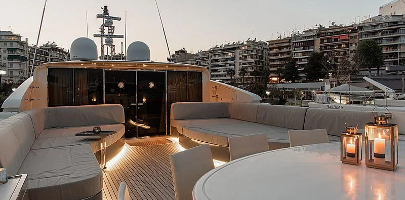 a room with couches and a table and a large city landscape aboard BEYOND Yacht for Charter