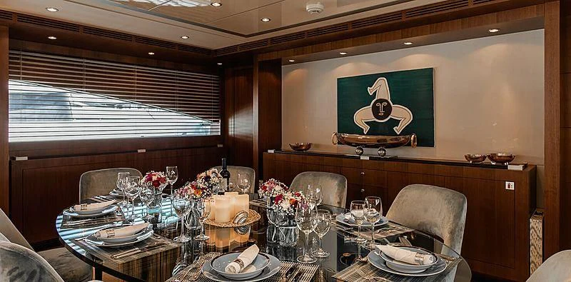 a dining room table with a painting on the wall aboard BEYOND Yacht for Charter