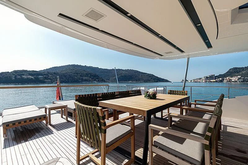 a table and chairs on a deck overlooking a body of water aboard THE UNIFIER KING ABDULAZIZ THE FIRST Yacht for Sale