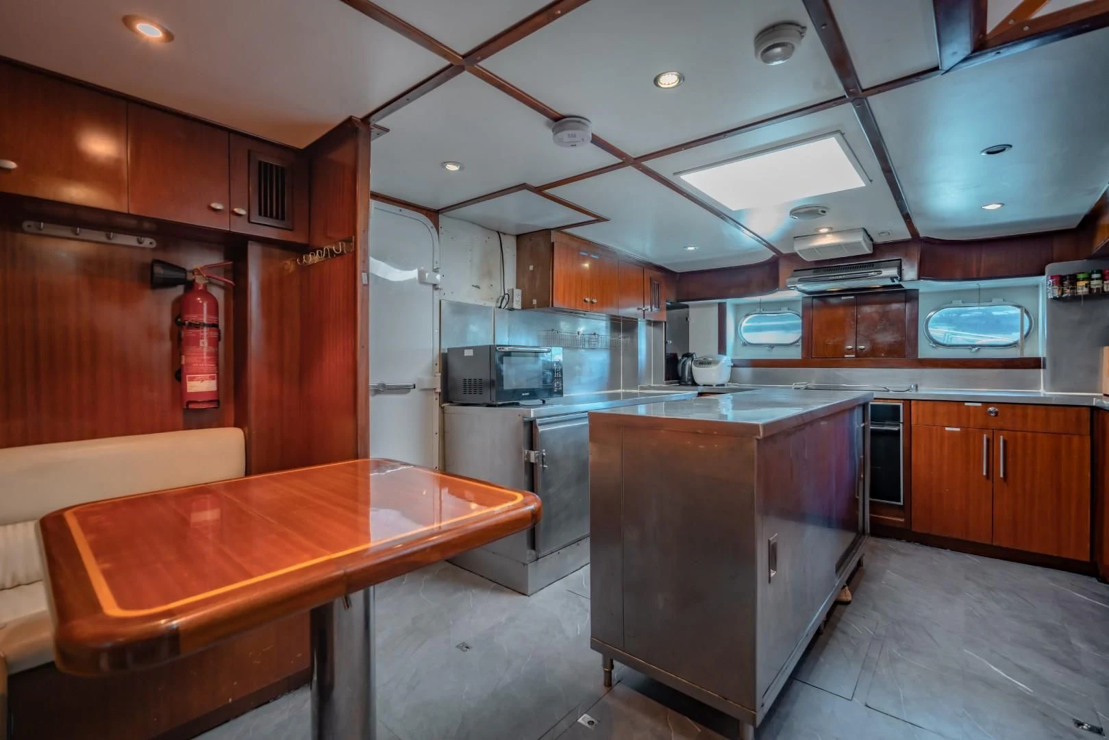 a kitchen with a table and a refrigerator aboard MIA KAI Yacht for Charter