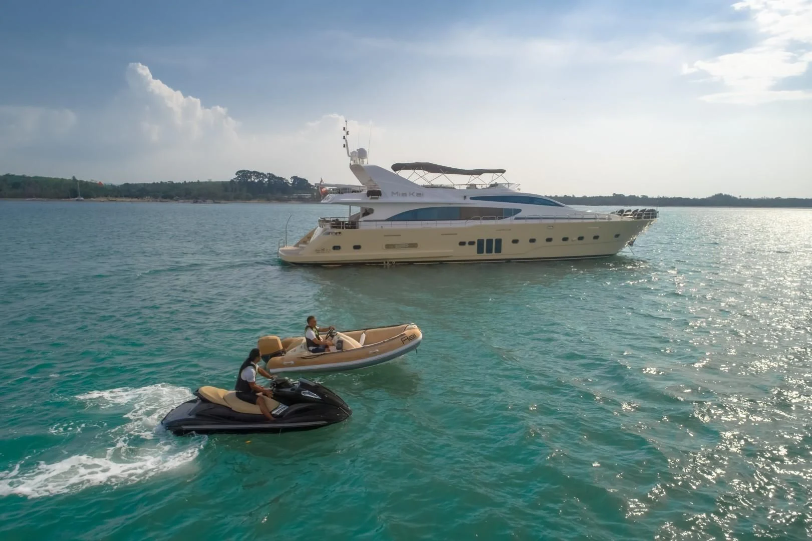 a boat and a couple people in a motorboat in the water aboard MIA KAI Yacht for Charter