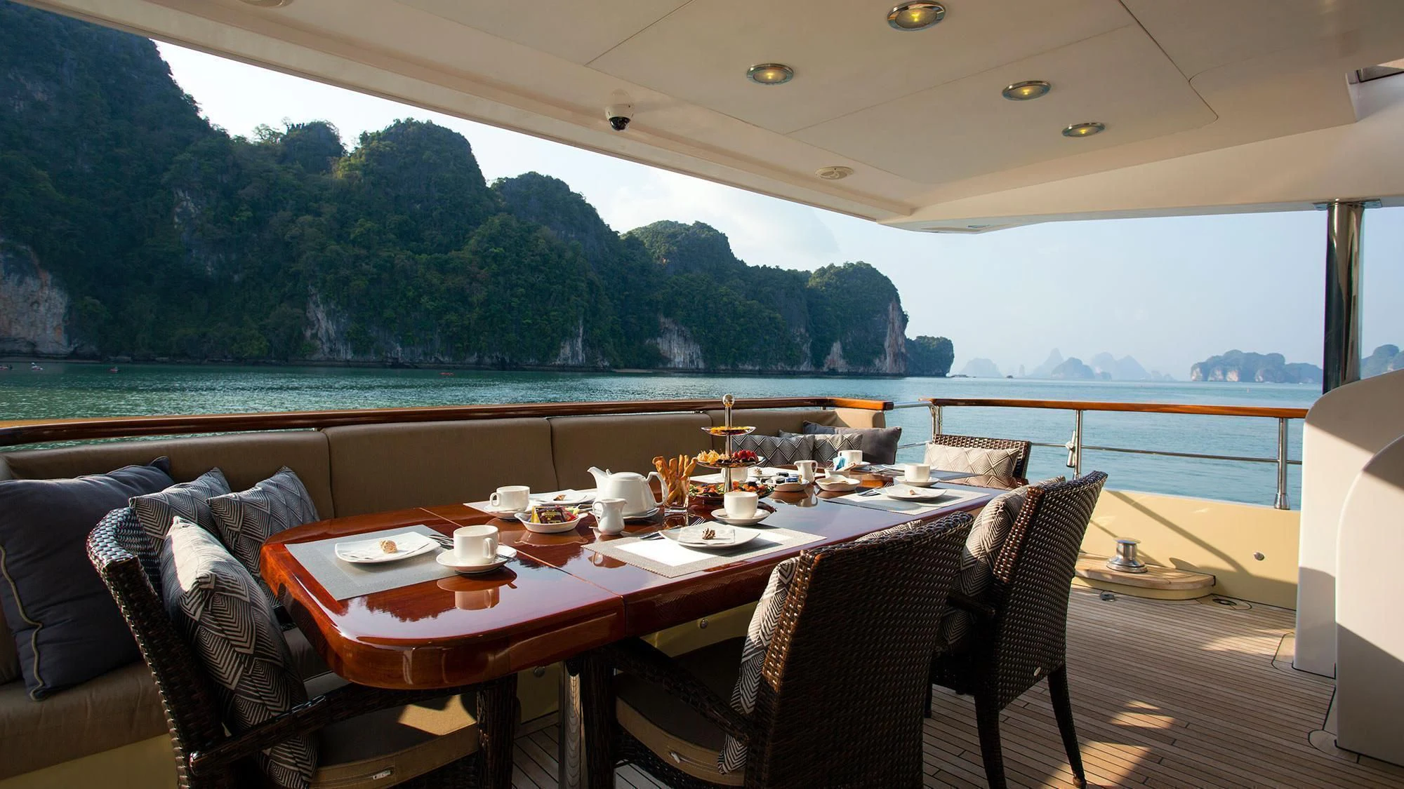a table with chairs and a view of a lake aboard MIA KAI Yacht for Charter