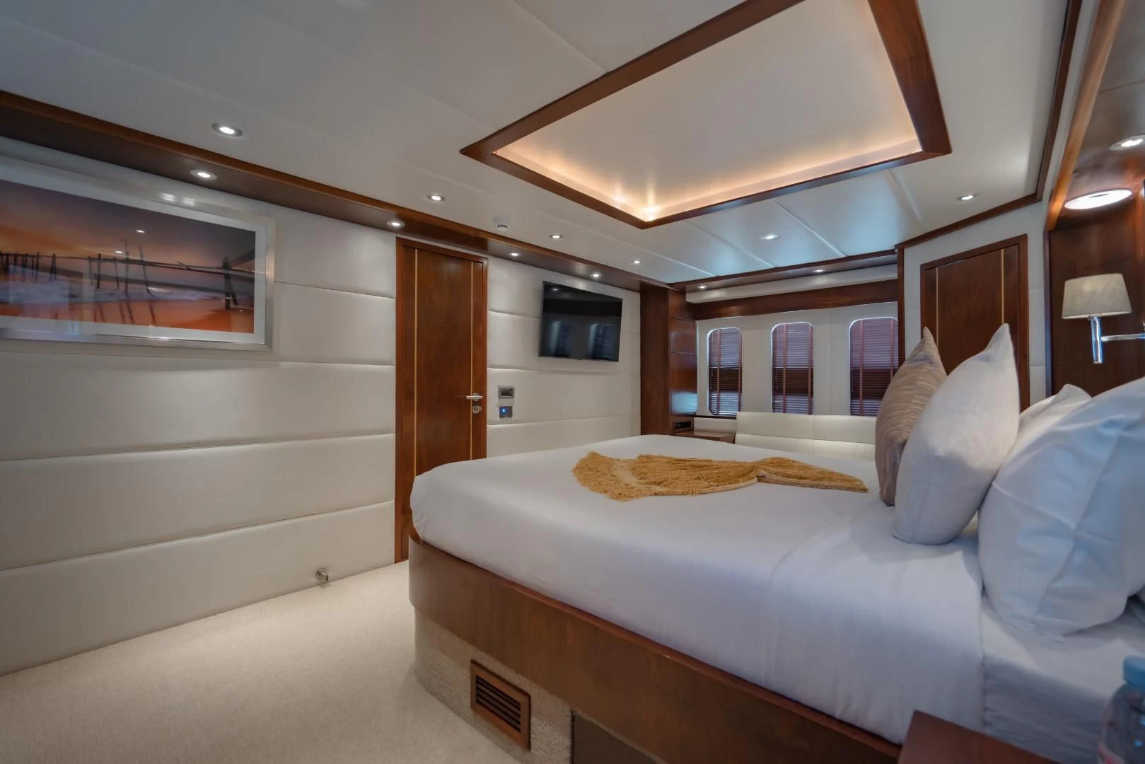 a bedroom with a bed and a television aboard MIA KAI Yacht for Charter