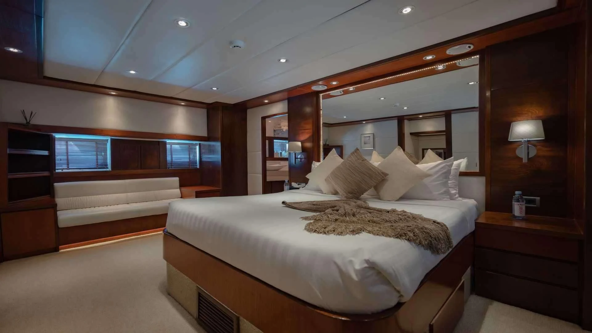 a room with a bed and a large mirror aboard MIA KAI Yacht for Charter