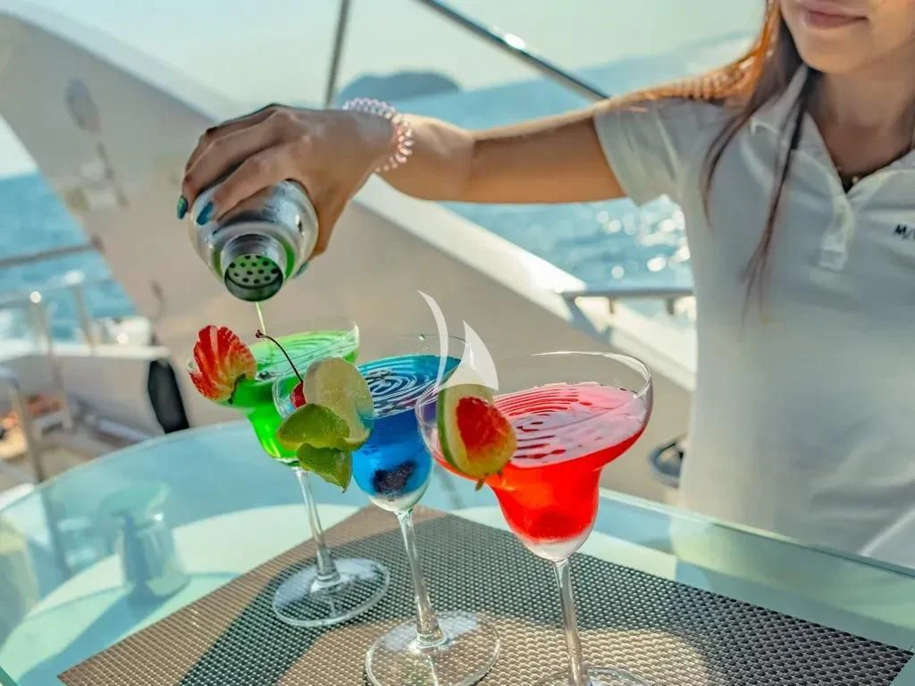 a woman pouring a bottle of wine into a glass aboard MIA KAI Yacht for Charter