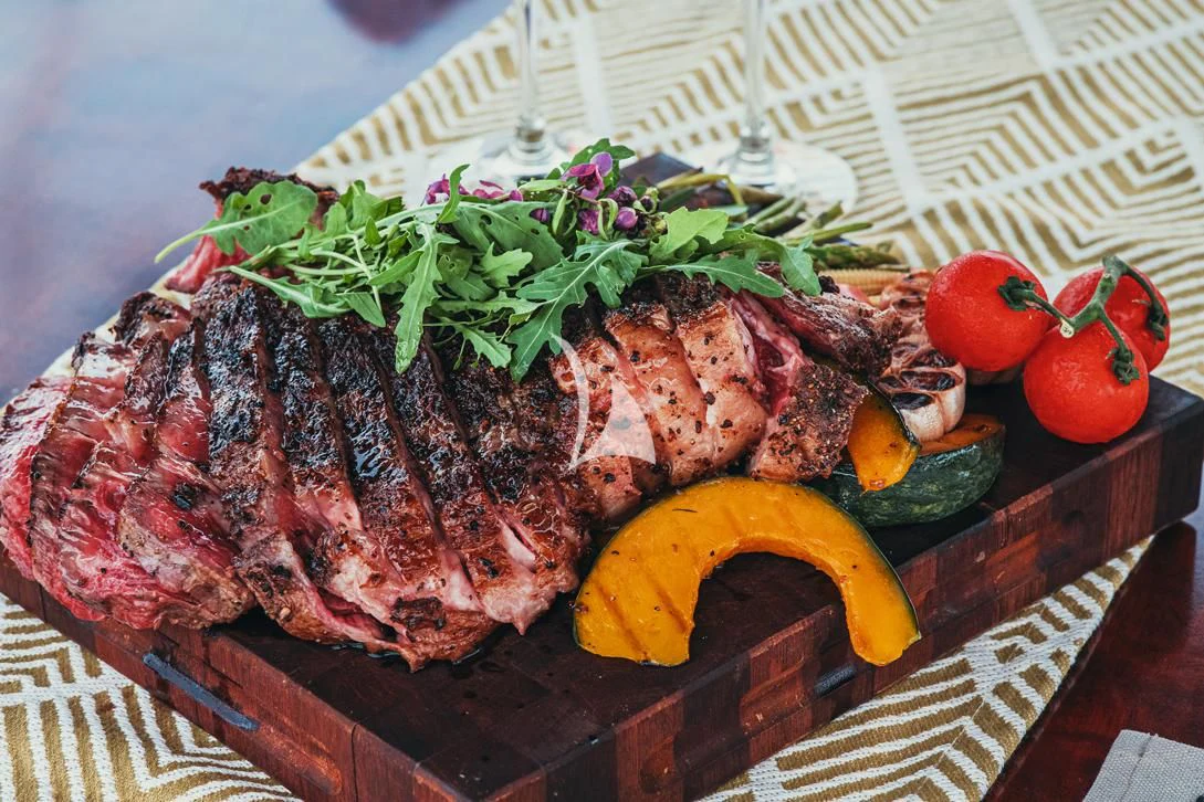a tray of meat and vegetables aboard MIA KAI Yacht for Charter