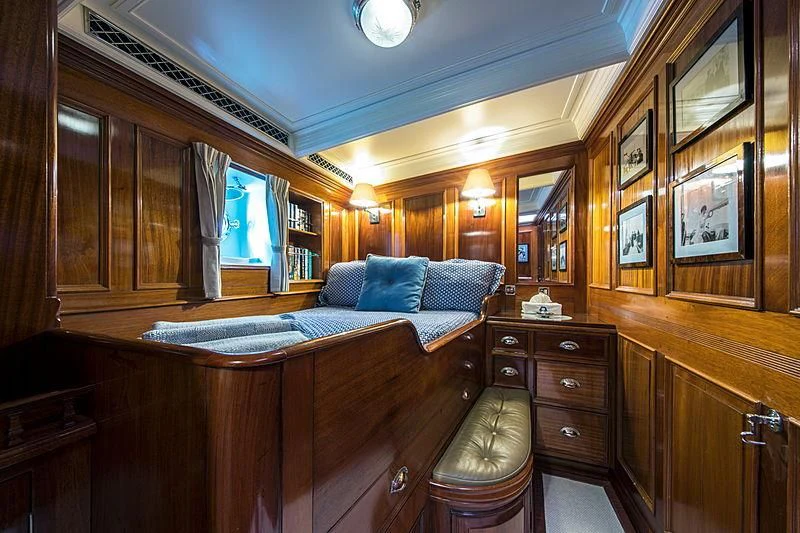 a bedroom with a bed and a dresser aboard ADELA Yacht for Sale