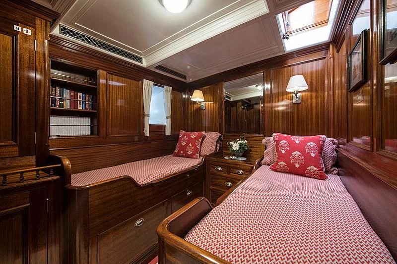 a bedroom with a bed and a bookcase aboard ADELA Yacht for Sale