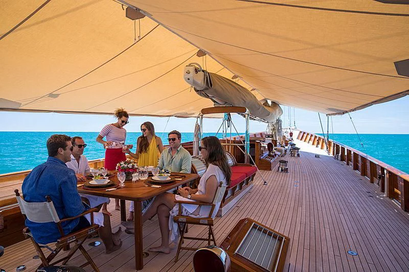 a group of people sitting at a table on a boat aboard ADELA Yacht for Sale