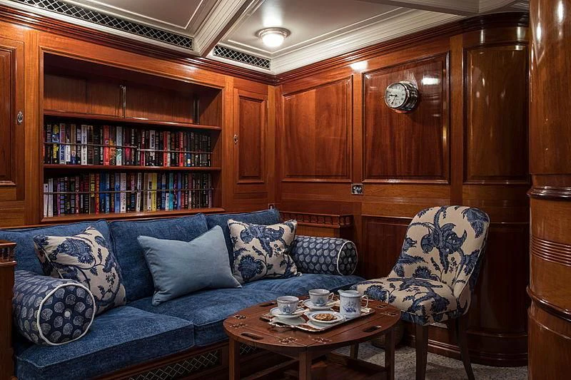 a living room with a blue couch aboard ADELA Yacht for Sale