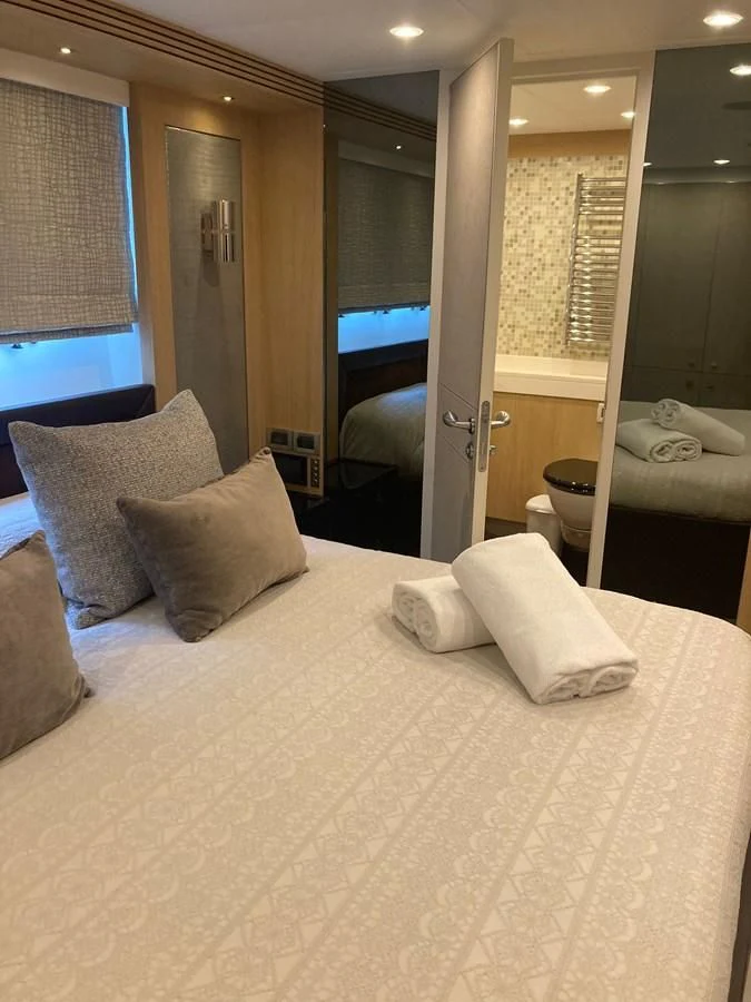 a hotel room with a bed and a large mirror aboard O NOSO UNO Yacht for Sale
