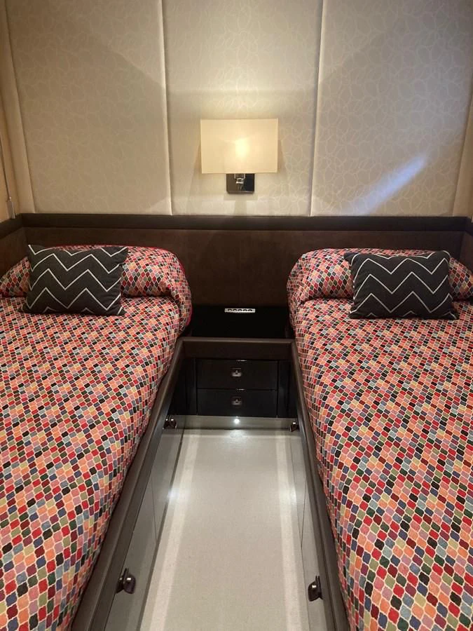 a bed with a plaid blanket aboard O NOSO UNO Yacht for Sale