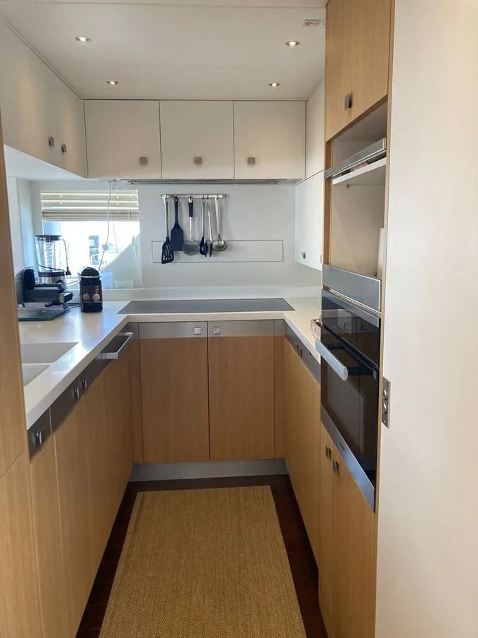 a kitchen with wooden cabinets aboard O NOSO UNO Yacht for Sale