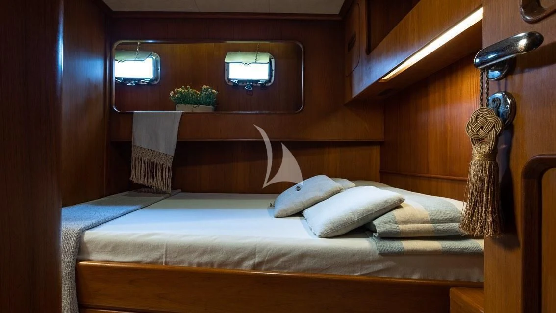 a bed with a white sheet and pillows aboard LOTTY Yacht for Sale