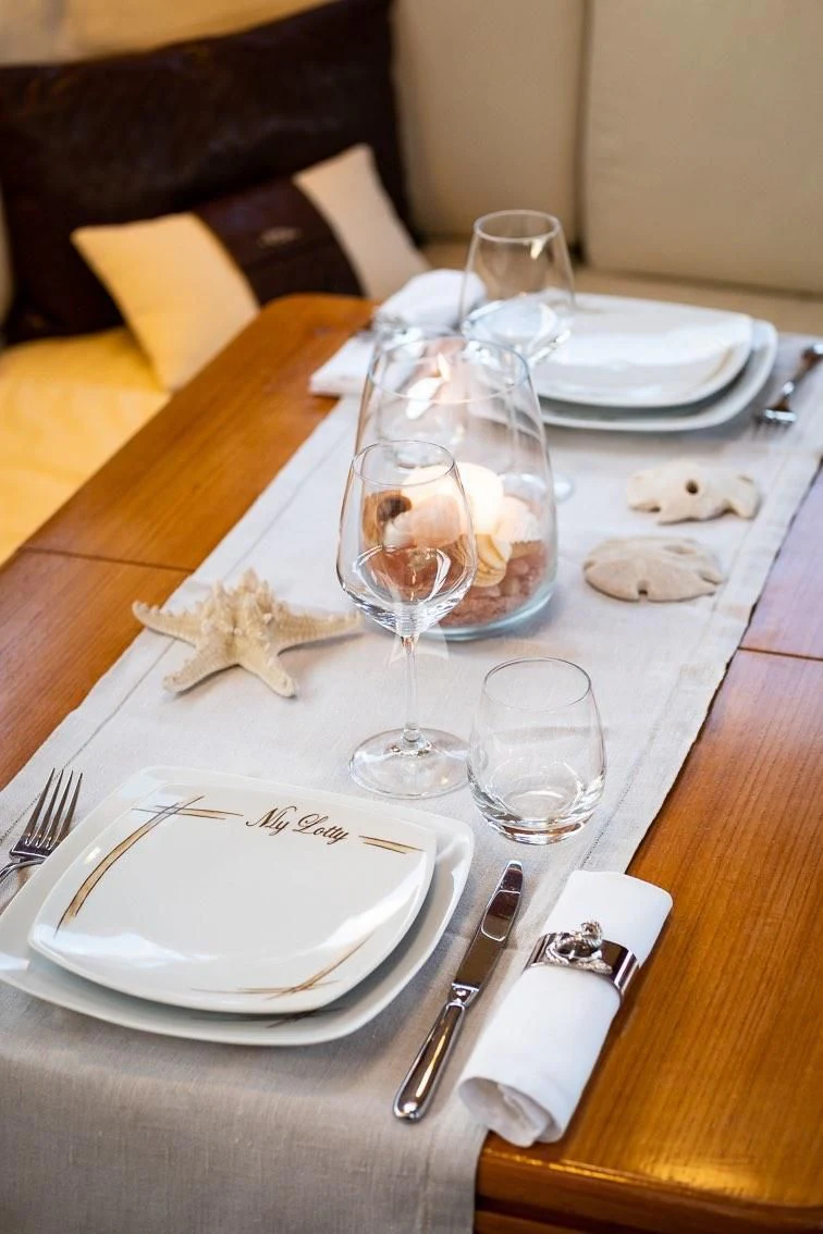 a table with plates and glasses on it aboard LOTTY Yacht for Sale