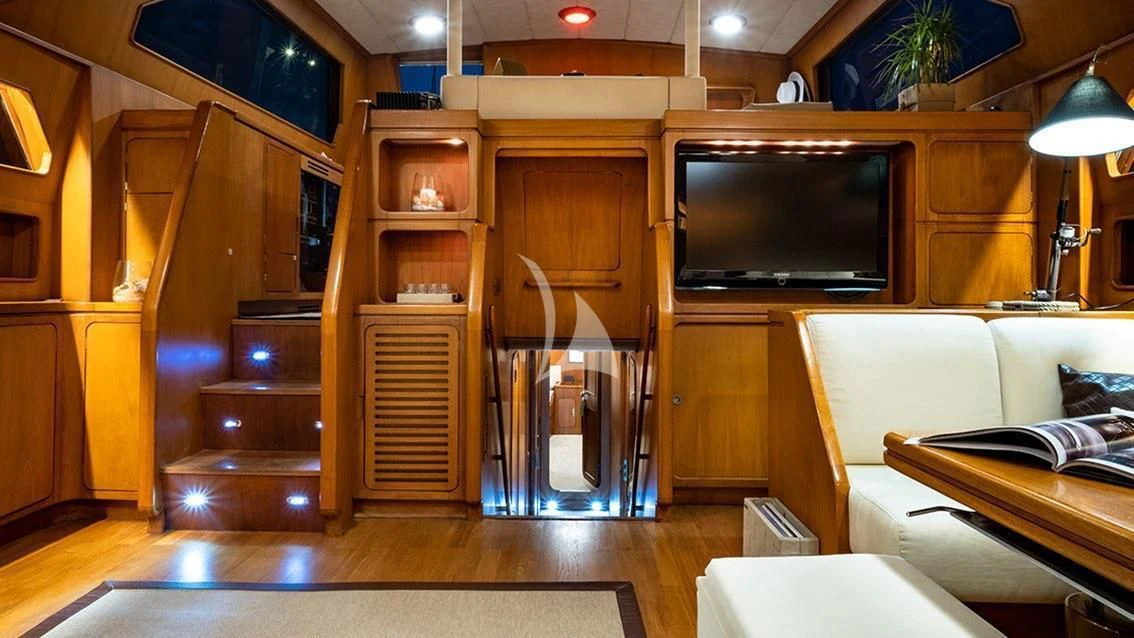 a living room with a tv and a bed aboard LOTTY Yacht for Sale