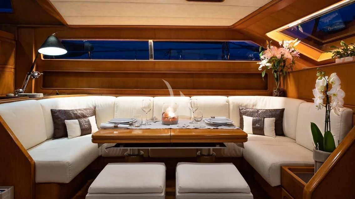 a room with a couch and a table with wine glasses on it aboard LOTTY Yacht for Sale