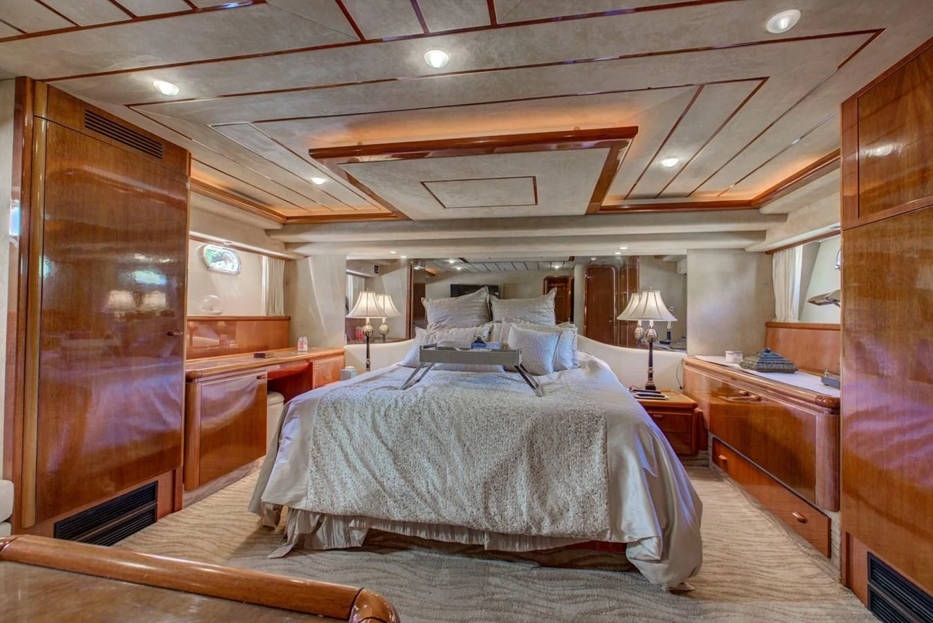 a bedroom with a bed and a wood cabinet aboard FERRETTI Yacht for Sale