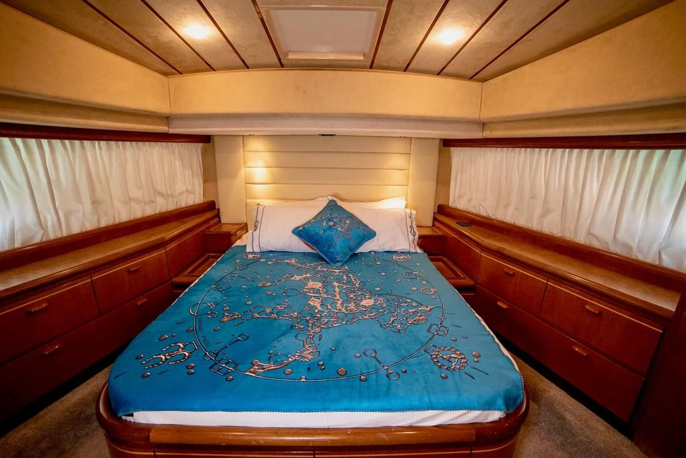 a bed with a blue comforter aboard FERRETTI Yacht for Sale