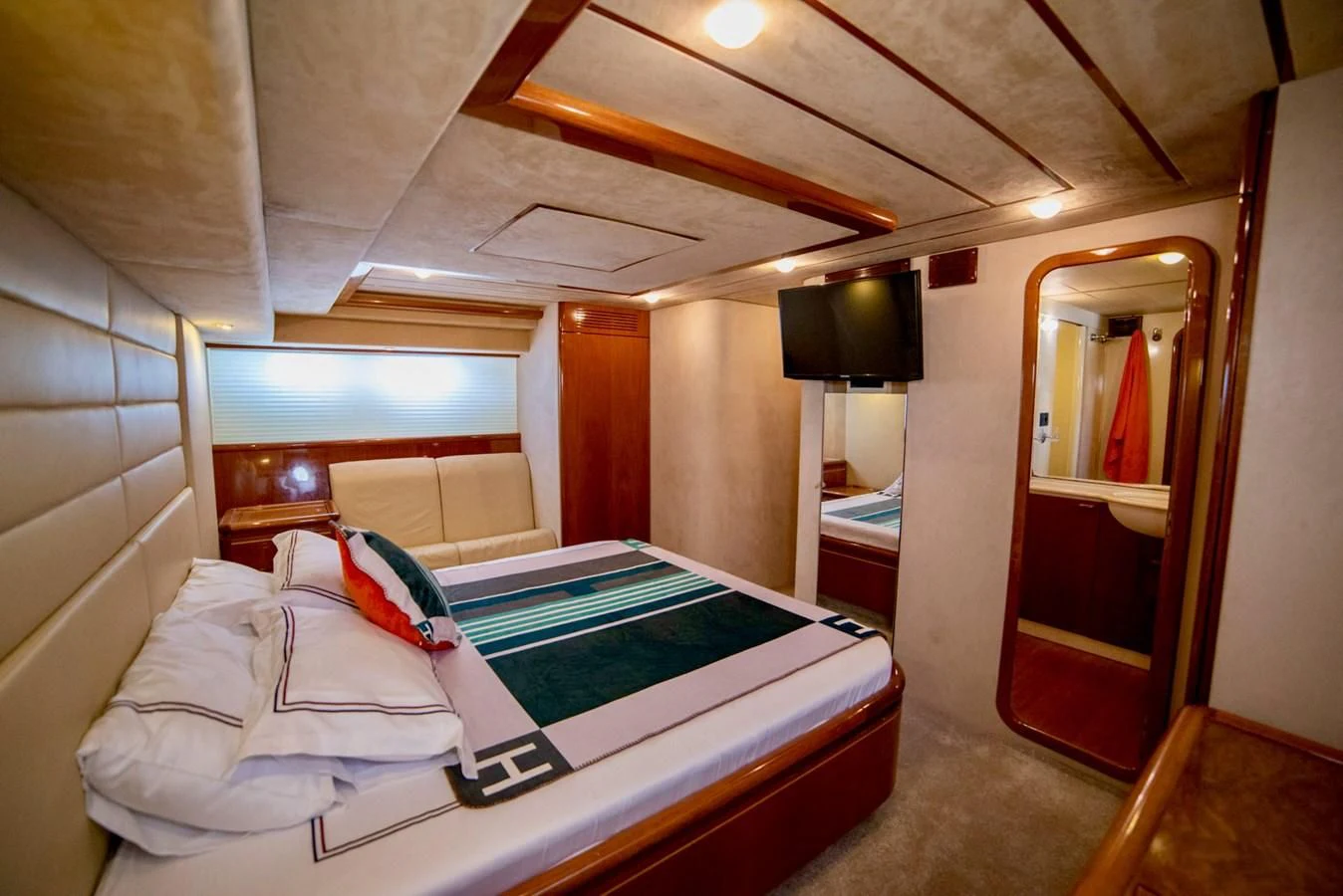 a room with a bed and a television aboard FERRETTI Yacht for Sale