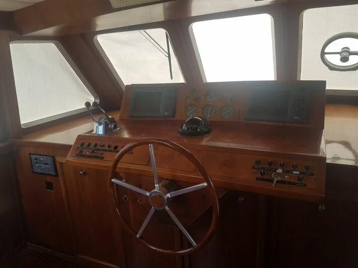 a wooden desk with a computer and a radio aboard MAXIME Yacht for Sale