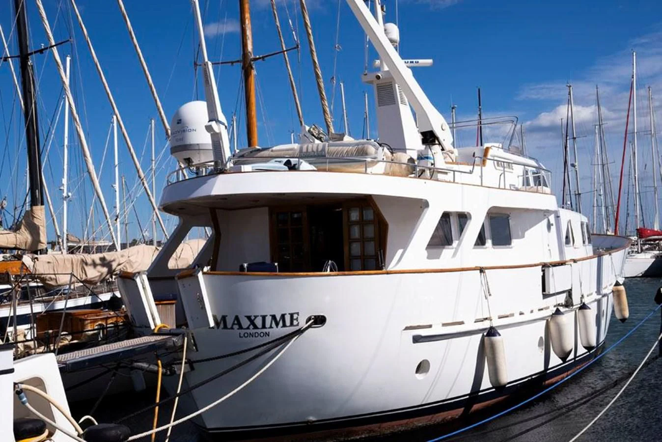 a white boat in a harbor aboard MAXIME Yacht for Sale