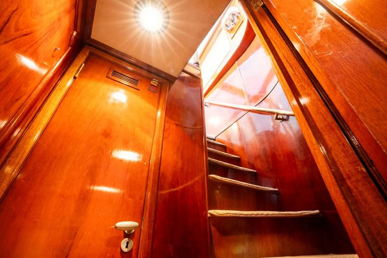 a wooden staircase with a light aboard MAXIME Yacht for Sale