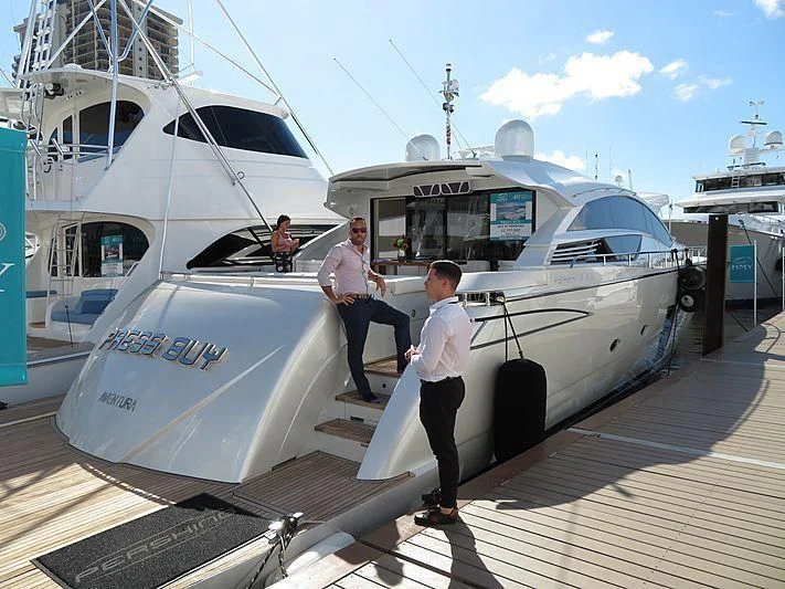 a couple of men standing next to a white boat aboard RAW 2-HP Yacht for Sale