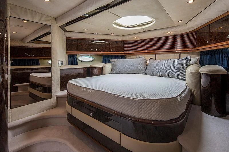 a room with a bed and a table aboard OSCAR Yacht for Sale