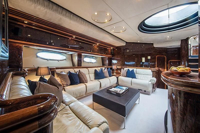 a living room with a large couch and a table aboard OSCAR Yacht for Sale