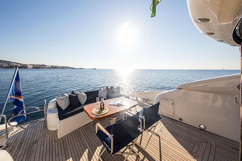 a deck with a table and chairs on it aboard OSCAR Yacht for Sale