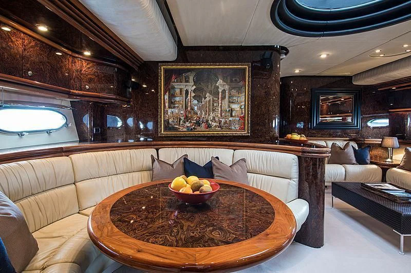 a living room with a table and couches aboard OSCAR Yacht for Sale