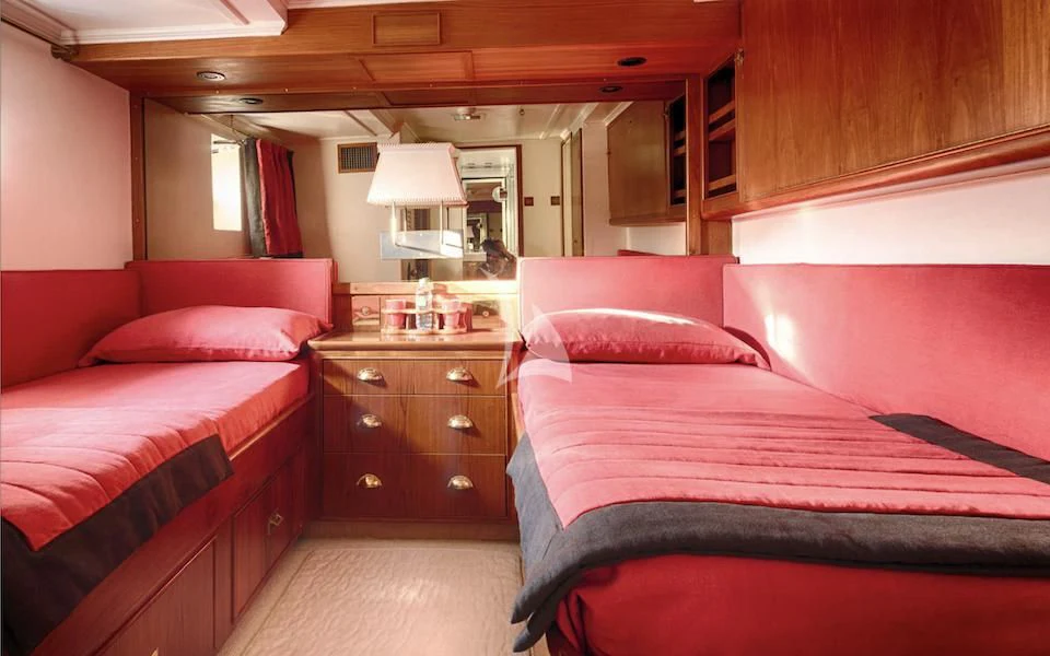 a room with a bed and a dresser aboard JURA II Yacht for Sale