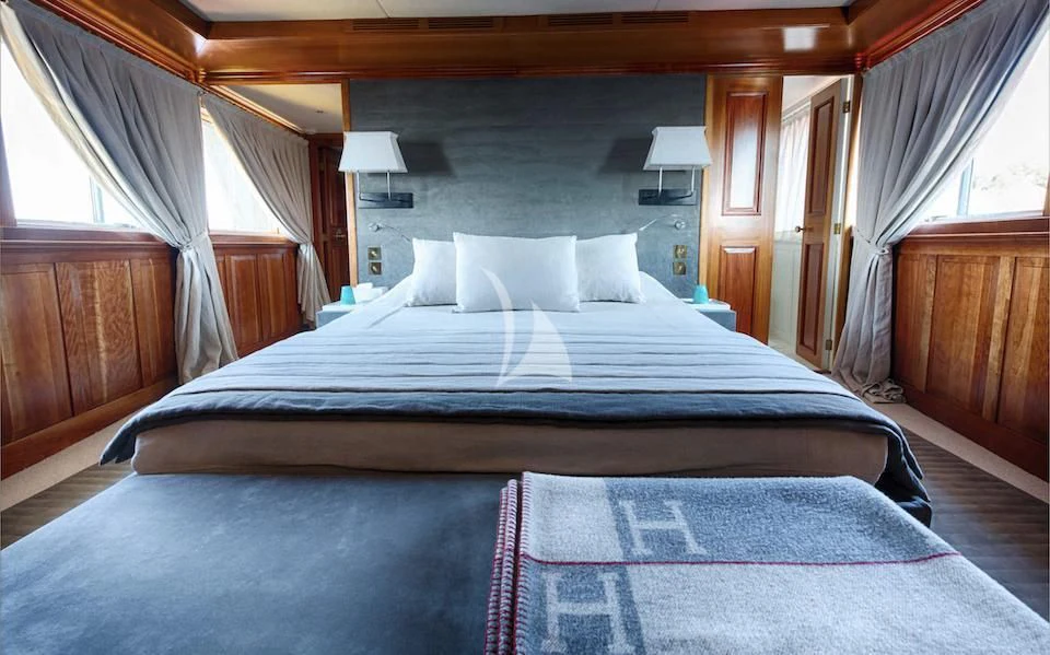a bed with a blue sheet aboard JURA II Yacht for Sale