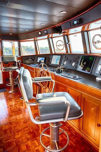a room with a bar and chairs aboard JURA II Yacht for Sale