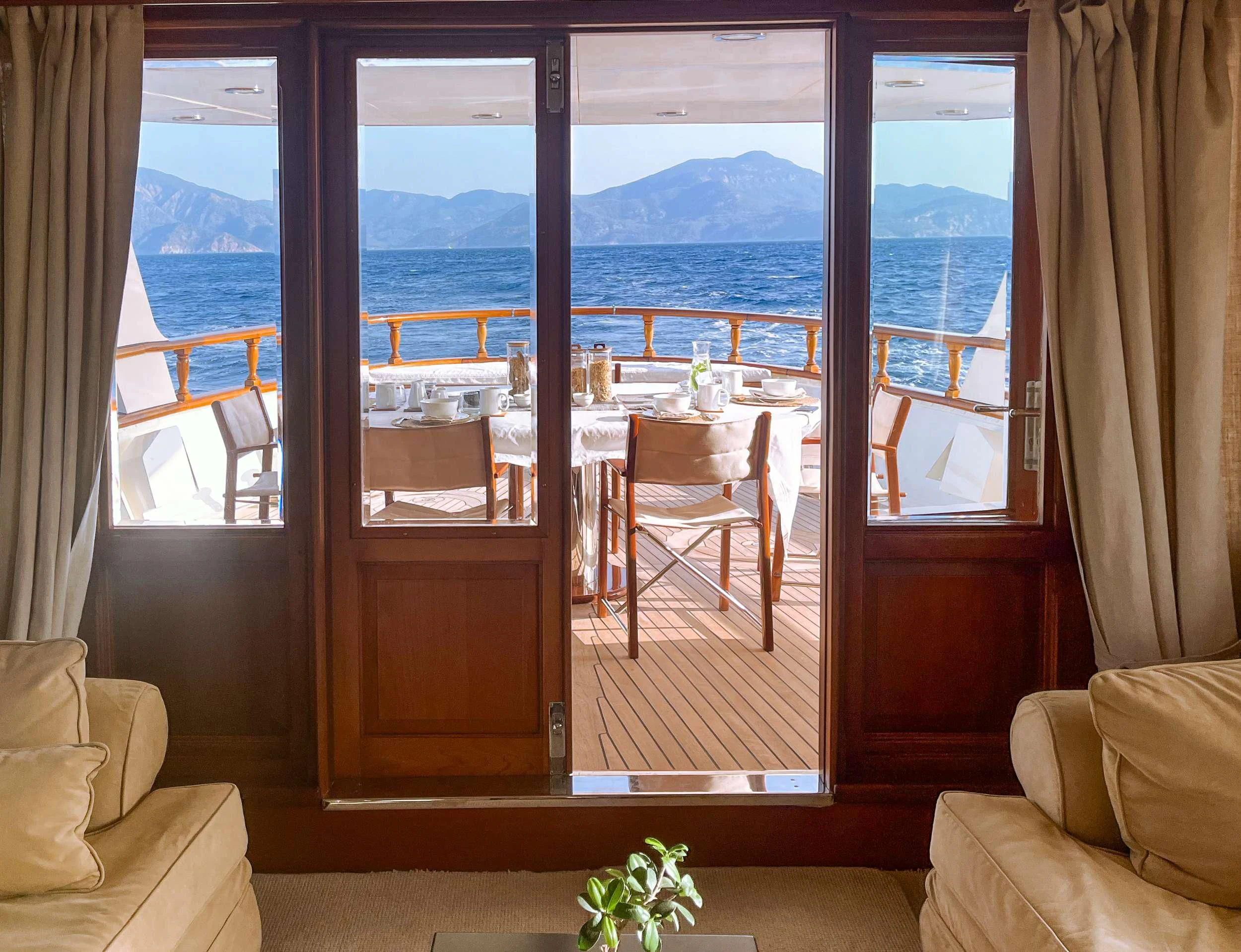 a room with a view of the ocean and the mountains aboard JURA II Yacht for Sale