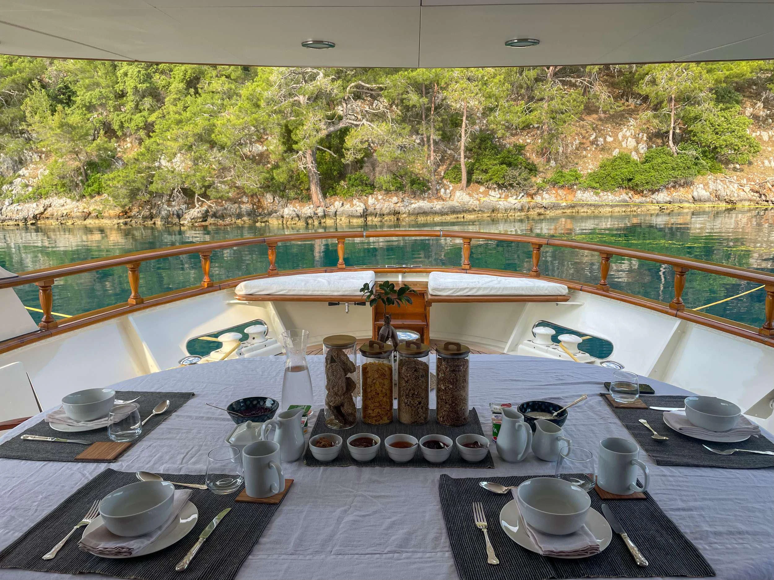 a table with plates and cups on it aboard JURA II Yacht for Sale